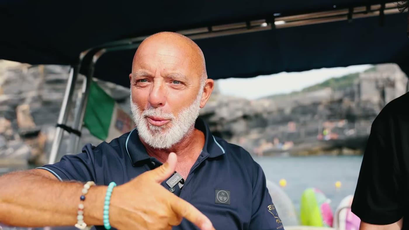 Marco racconta a bordo, con la costa del Golfo dei Poeti alle spalle